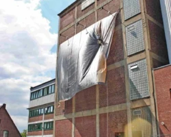 Industriekletterer montiert Banner an Fassadenfront in Bochum