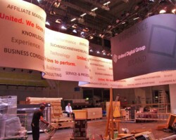 Industriekletterer montiert Werbegrafik bei Messe auf hoher Fassade in Düsseldorf